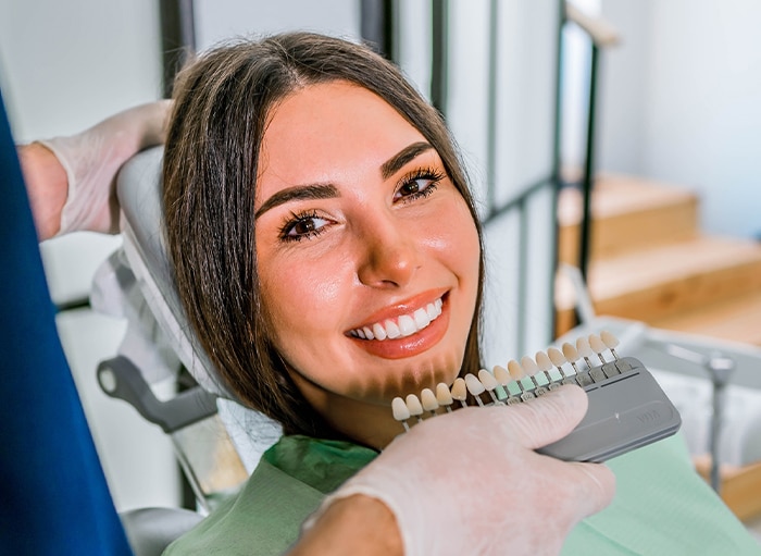 Dentist comparing porcelain veneers to a patient's mouth