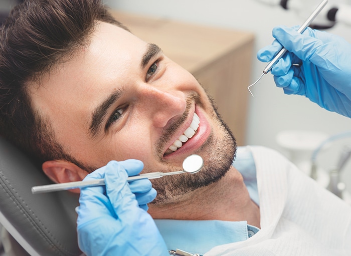 Dentist preparing to inspect a man's teeth